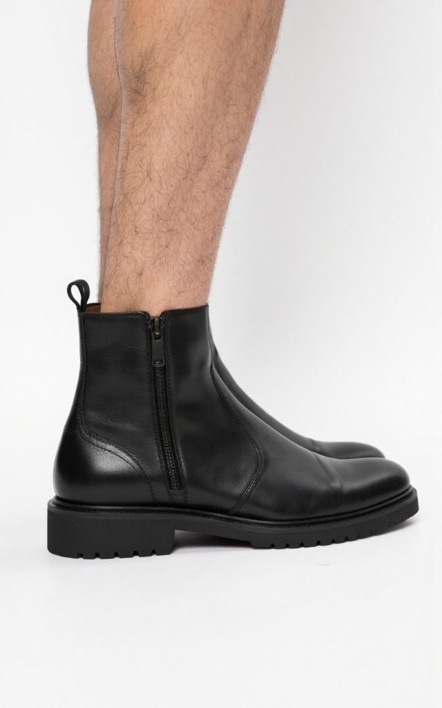A male model wearing Ankle boots with zipper, against a white background, with a close   up of the feet